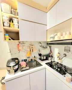 uma cozinha branca com um lavatório e um fogão em BnB House Villa Jogja em Balong