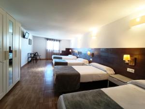 a row of beds in a hotel room at Hospedería Los Angeles in Córdoba