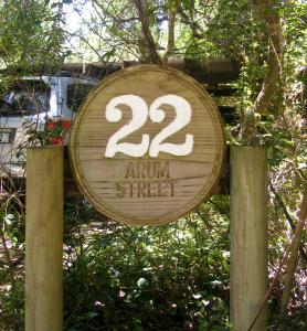ein Holzschild mit der Nummer der jährlichen Straße in der Unterkunft 22 Arum Street Nature’s Valley in Natureʼs Valley