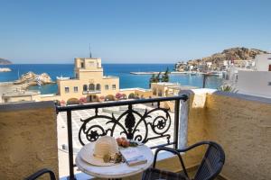 a table on a balcony with a view of the ocean at Atlantis Hotel in Karpathos Town