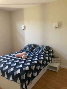 Schlafzimmer mit einem Bett mit einer blauen und weißen Bettdecke in der Unterkunft villa familiale de caractere in Casteljaloux