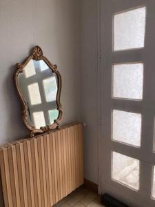 ein Spiegel auf einem Heizkörper neben einem Fenster in der Unterkunft villa familiale de caractere in Casteljaloux