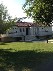 uma casa branca com um alpendre e um quintal em villa familiale de caractere em Casteljaloux