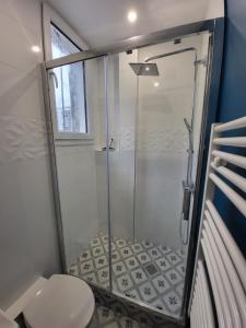 y baño con ducha y aseo. en Charmant studio Ménilmontant en París