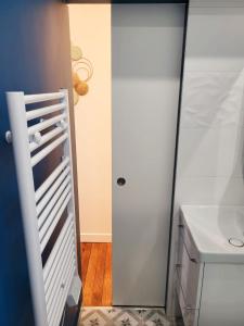 ein Badezimmer mit einem weißen Schrank und einem Waschbecken in der Unterkunft Charmant studio Ménilmontant in Paris