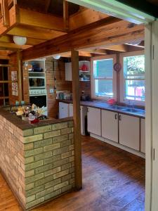 a kitchen with white cabinets and a brick wall at 22 Arum Street Nature’s Valley in Natureʼs Valley