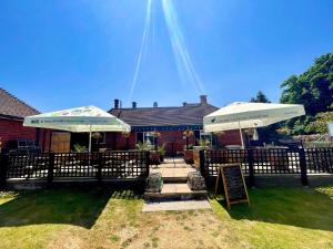 a patio with two umbrellas in front of a house at The Fishmongers Tavern in Sheringham