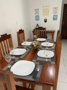 a dining room table with white plates and wine glasses at Charme Barra Mar in São Luís