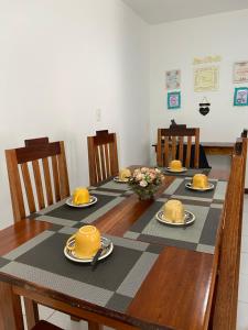 a dining room table with chairs and yellow hats on it at Charme Barra Mar in São Luís