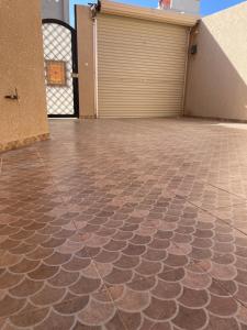 a garage with a tiled floor in front of a garage door at شقة فاخرة للعوائل دور ارضي مع فناء خارجي in Riyadh Al Khabra