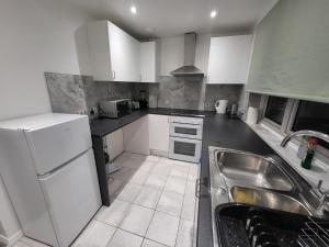 a kitchen with white appliances and a sink at Cosy 2 Bedroom flat in Grays in Grays Thurrock
