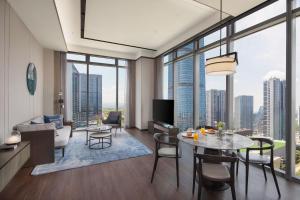 uma sala de estar com uma mesa e cadeiras e uma grande janela em Marriott Executive Apartments Hangzhou em Hangzhou