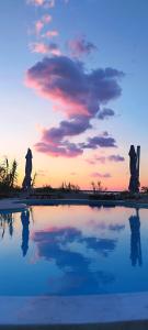a pool of water with a sunset in the background at Aparthotel Dalmacija in Privlaka
