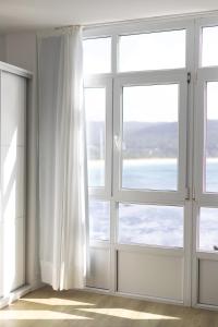 Habitación vacía con puertas correderas y ventanas en Hotel Mar de Fisterra, en Finisterre