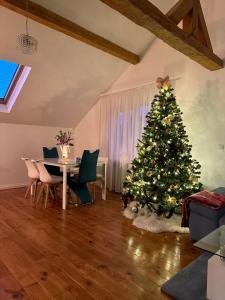 a christmas tree in a living room with a table and chairs at Attic 33 in Câmpulung Moldovenesc