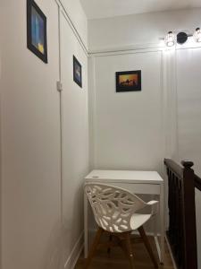 een witte kamer met een stoel en een bureau bij Charmant Cocon en duplex avec jardin in Noisy-le-Sec