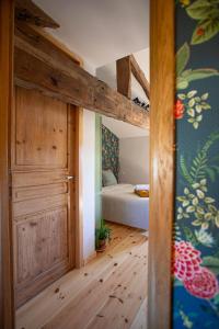 1 dormitorio con 1 cama y puerta de madera en La Fée Capucine - Chambres et table d'hôtes - Espace bien-être et massages, en Saint-Galmier