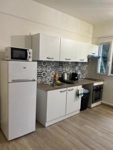 een keuken met witte kasten en een witte koelkast bij Charmant Cocon en duplex avec jardin in Noisy-le-Sec