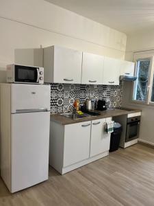 a kitchen with white cabinets and a white refrigerator at Charmant Cocon en duplex avec jardin in Noisy-le-Sec