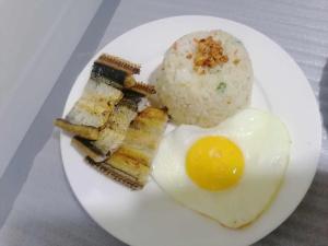 a plate of food with an egg and rice at Siayanrock Hometel in Ivana
