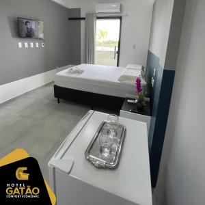 um pequeno quarto com uma cama e uma bandeja no balcão em HOTEL GATAO em Sobral