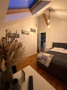 a bedroom with a bed and a table with a remote control at Attic 33 in Câmpulung Moldovenesc