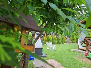 een tuin met twee stoelen en een boom bij Ferienhaus "BASTEK2" am See mit Kamin & WLAN - Domek Letniskowy BASTEK in Pasym