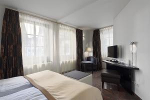 a hotel room with a bed and a desk and window at TRIP INN Kaiser Hotel & Restaurant Heidelberg-Schriesheim in Schriesheim