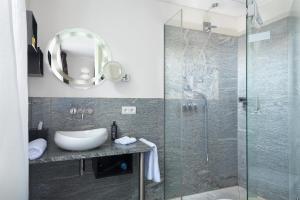 W łazience znajduje się umywalka i przeszklony prysznic. w obiekcie TRIP INN Kaiser Hotel & Restaurant Heidelberg-Schriesheim w mieście Schriesheim