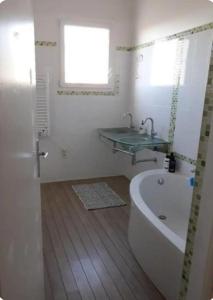a bathroom with a bath tub and a sink and a bath tub at Chambre Luxurieux Gris in Perpignan