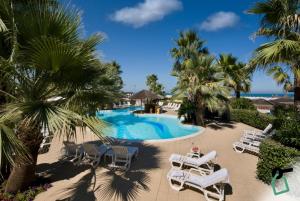 a resort with a pool and chairs and palm trees at HOTIDAY Room Collection - Giulianova in Giulianova