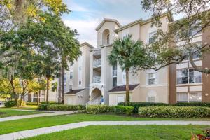 a large apartment building with trees in front of it at Hilton Vacation Club Grande Villas Orlando in Orlando
