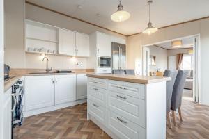 a kitchen with white cabinets and a counter top at Lodge 82 The Lyndale 10 minute drive to St Andrews in Cameron