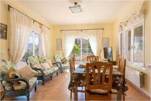 a living room with a table and chairs and a television at Villa Amelia - PlusHolidays in Ifach