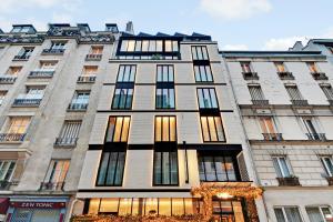 um edifício alto com muitas janelas numa rua em CARD Hôtel em Paris