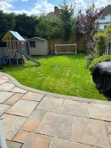 a yard with a playground with a slide at Enjoy a Luxury & Peaceful Home in Loughton, Essex in Loughton
