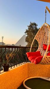 a porch swing with red pillows on a balcony at Royal Pyramids Museum Guest House in Cairo