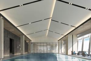 a swimming pool in a building with windows at Qingdao Marriott Hotel Jiaozhou in Qingdao
