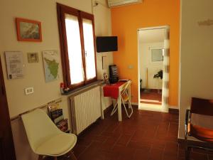 een kamer met een tafel, een stoel en een raam bij Geoglobe Chambre d'Hòtes in Pisa