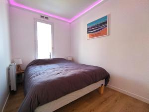 a bedroom with a bed in a room with purple lights at Très bel appartement à 2 minutes de la plage de Tanchet - 4 pers in Les Sables-d'Olonne