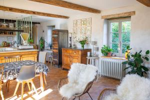 a kitchen and dining room with a table and chairs at La Fée Capucine - Chambres et table d'hôtes - Espace bien-être et massages in Saint-Galmier