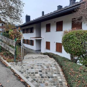 uma casa branca com um caminho de pedra à sua frente em Ferienwohnung Leni em Sonthofen