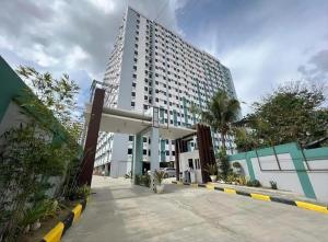 un edificio alto con un estacionamiento delante de él en white room 2BR condo in banilad cebu, en Mandaue