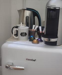een aanrecht met een koffiezetapparaat en kopjes op de koelkast bij Chambre LOVE ROOM 35m2 avec LIT ROND Balnéo Hammam vidéoprojecteur in Jardin