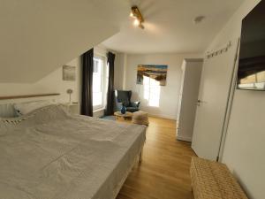 sypialnia z dużym łóżkiem i salonem w obiekcie Ferienhaus Deich Frida w mieście Breege