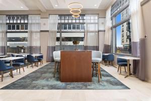 a lobby with tables and chairs and large windows at Hampton Inn Kansas City - Downtown Financial District in Kansas City