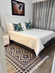 a bedroom with a large bed with a rug at Sarona LoLa E206 in Gaborone