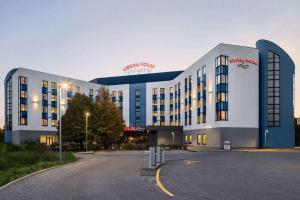 a large building with a parking lot in front of it at Vienna House Easy by Wyndham Bratislava in Bratislava