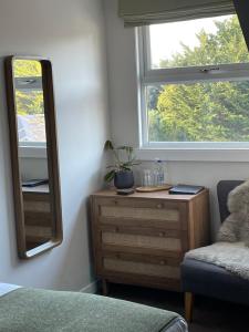 a bedroom with a dresser and a mirror at Falmouth Bay in Falmouth