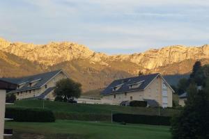 un groupe de maisons avec des montagnes en arrière-plan dans l'établissement Belle maison de 140 m2, à Villard-de-Lans